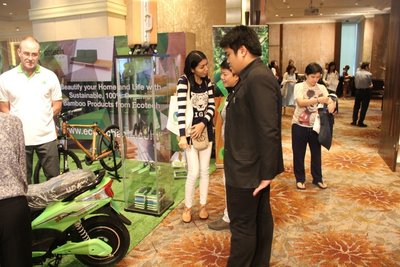 與會者在Eco Tech Asia的展台參觀竹質行李箱、竹質自行車(APC Boo Bikes)和其他環保產品