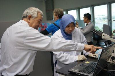 IWK officer showing Dato’ Teo the microorganisms living in the water in the lab