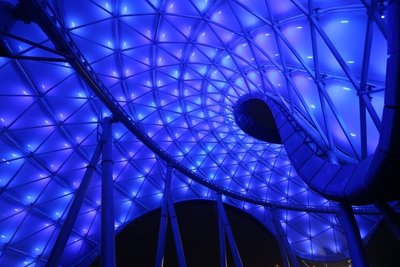 在明日世界，一座巨大的、色彩绚丽变幻的穹顶在夜空点亮。穹顶之下充满刺激的全新游乐设施 -- 创极速光轮的测试也在持续进行中。
