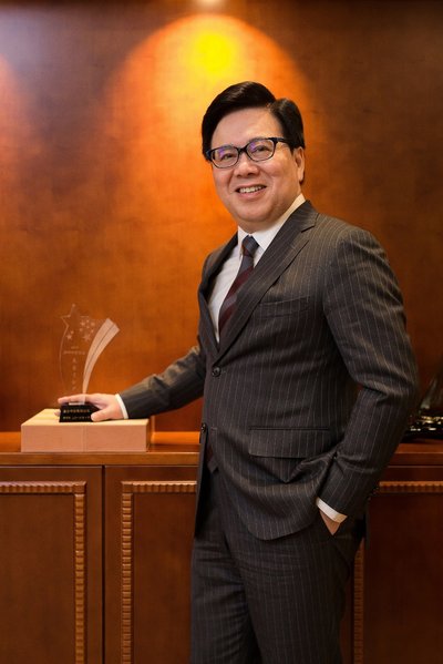 Sands China Ltd. President Dr. Wilfred Wong stands next to the company’s Outstanding Contribution Award trophy from the Summit Forum for the Development of Foreign Enterprises in China