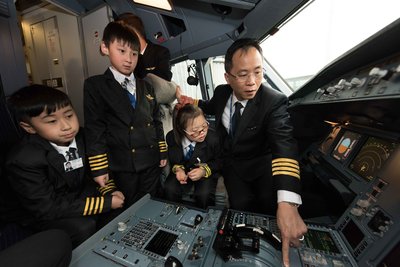 孩童登入香港航空的飞机驾驶舱，在香港航空机长的讲解下，了解飞机构造及运作