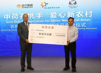荷兰皇家菲仕兰全球首席执行官鲁乐夫（左）向中国扶贫基金会执行副会长王行最（右）捐赠100万元
