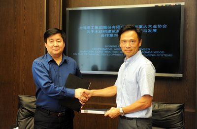 加拿大木业总裁黄华力（右）与上海建工集团总工程师龚剑（左）代表双方单位签约