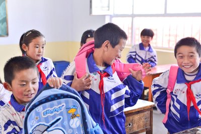 互助土族自治县松多乡中心学校的孩子们领到新书包后非常开心