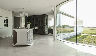 荷兰傍水别墅厨房空间的料理岛台，烹饪台面和橱柜表面由杜邦TM可丽耐®实体面材奶白色完成。项目拍摄：Koen Olthuis – Waterstudio.NL，版权所有。