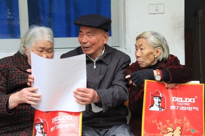 温州北白象镇敬老院的老人们高兴地传阅德力西电气的新春福袋