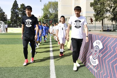 国安球员张辛昕、姜涛为小球员们助威，并与小球员们在赛场上热身互动