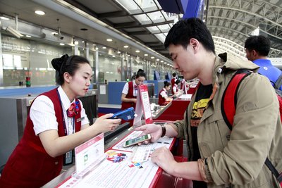 4月27日下午，成都双流机场T1候机楼内，旅客在川航值机柜台前用微信扫码支付逾重行李费。