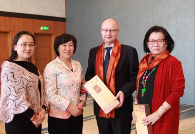 Fu Junli, Honorary President of Sanya People's Association for Friendship with Foreign Countries, giving Sanya-themed gifts to Heidi Wang, a member of the Copenhagen City Council, and Jasper Schou, an official from the Copenhagen municipal government, at The Sanya Celebration promotional meeting
