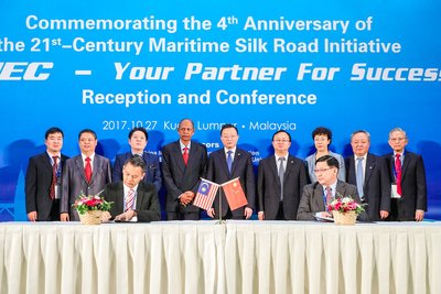 Several important guests, including Malaysia-China Friendship Association president Dato Abdul Majid Khan (fourth from left, back row) and CMEC president Zhang Chun (fifth from left, back row), witness the signing of a cooperation agreement between Chinese and Malaysian companies during the event