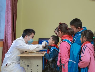 牙医志愿者为学生进行义务口腔检查