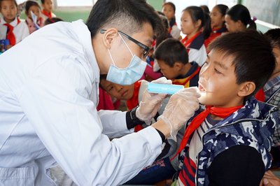 专业牙医志愿者为学生检查口腔