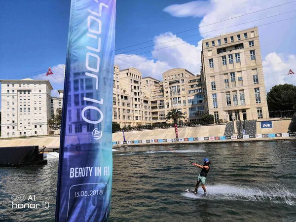 A wakeboarder passing by an Honor-branded flag (photo taken with Honor 10)