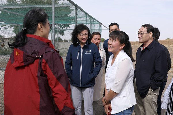Visa公司与中国扶贫基金会一同走访了中和农信农村贷款客户。图为 Visa 大中华区总裁于雪莉女士（左二）与孔雀养殖户孟兰（右前一）亲切交谈