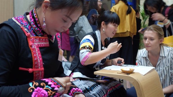 来自彝族和苗族的绣娘向现场中外来宾展示精湛的传统非遗手工技艺