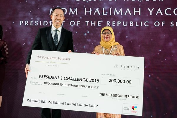 新加坡总统 Madam Halimah Yacob 从信和集团副主席黄永光先生手上接过代表善款的支票。