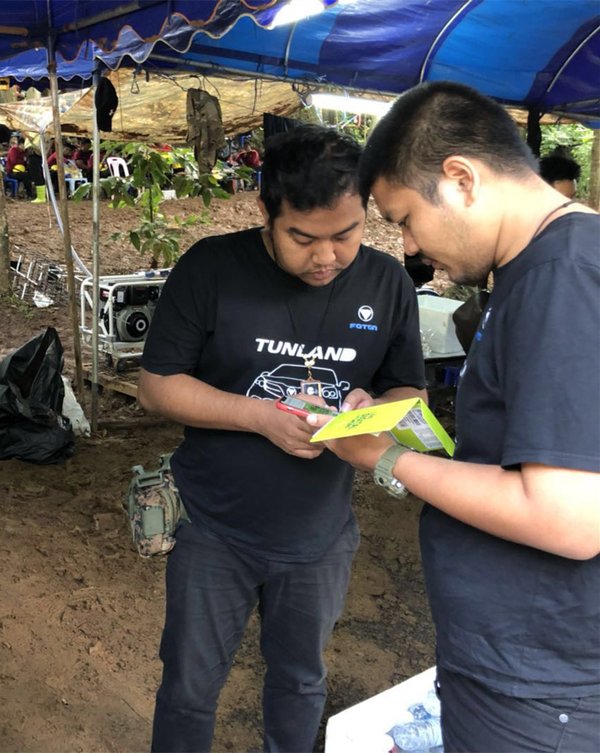 Phanuwat dan Apichart dari Foton Thailand membantu seorang anggota tim penyelamat ketika memperbaiki peralatan komunikasi