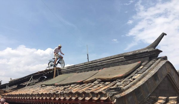 张京坤在拍摄电影《邪不压正》中屋顶骑行的片段