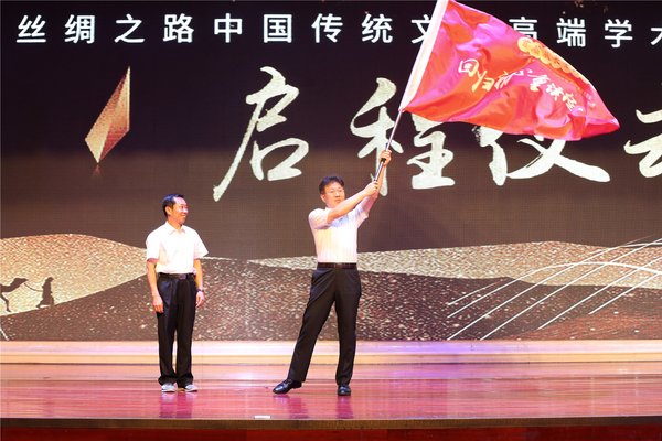 乌永陶将“回归初心、重读经典”的队旗授予中国网副总编辑、此次学术交流活动的领队薛立胜
