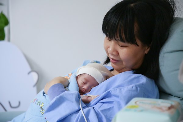 早产儿妈妈在专业医护人员指导下体验 “袋鼠抱抱”姿势