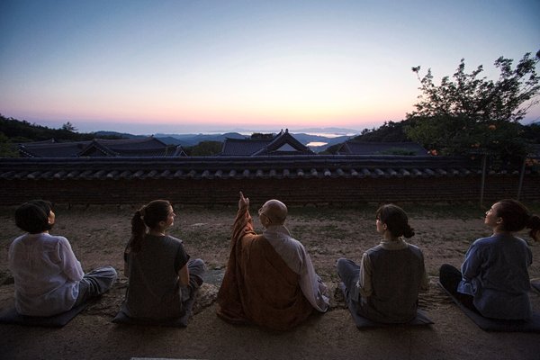 Một tu sĩ và những người tham gia Templestay ngắm hoàng hôn ở đền Mihwangsa