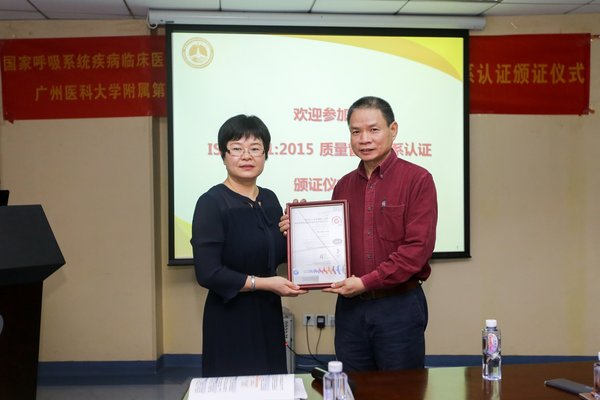 SGS认证及企业优化部华南及华中区总监张秋妹女士（左）给临床中心副主任郑劲平教授（右）颁发ISO 9001:2015认证证书