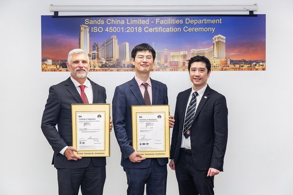 英国标准协会（BSI）香港总经理李志行（右）向金沙中国有限公司首席事务长郑君诺（中）及威尼斯人澳门股份有限公司设施管理部高级副总裁黎米高（左）颁授ISO 45001:2018职业健康和安全管理体系认证；这是公司目前获颁发的第五项ISO国际标准认证。