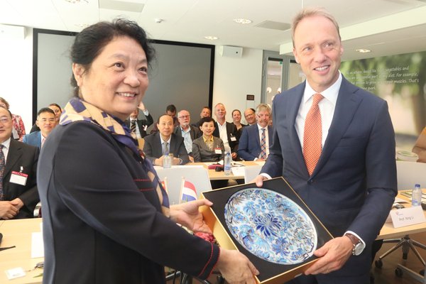 中国食品科学技术学会理事长孟素荷（左一）与荷兰皇家菲仕兰全球首席执行官司马翰（右一）互赠礼物