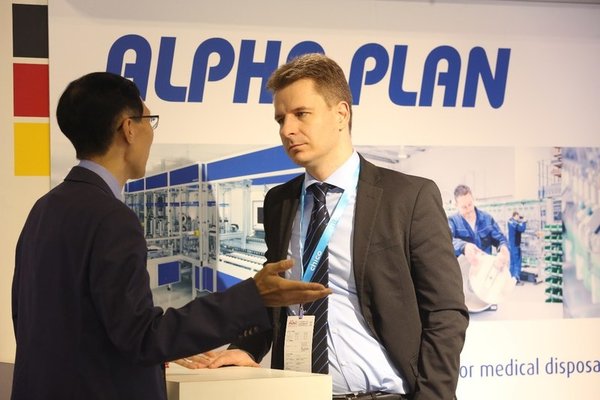 An exhibitor communicating with a visitor to the German pavilion