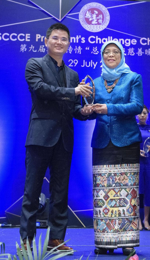 新加坡总统哈莉玛在“翰墨传情”慈善晚宴上为立思辰留学罗成颁奖