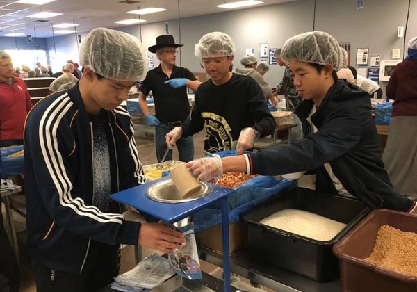 Amerigo双子城校区克雷汀德拉姆庄园高中的国际学生在当地公益机构为贫困家庭准备食材