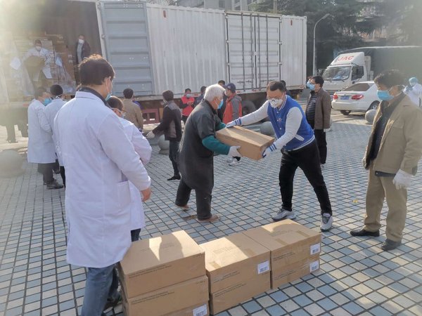 菲仕兰志愿者张平成（右三）和医护人员一起搬运物资