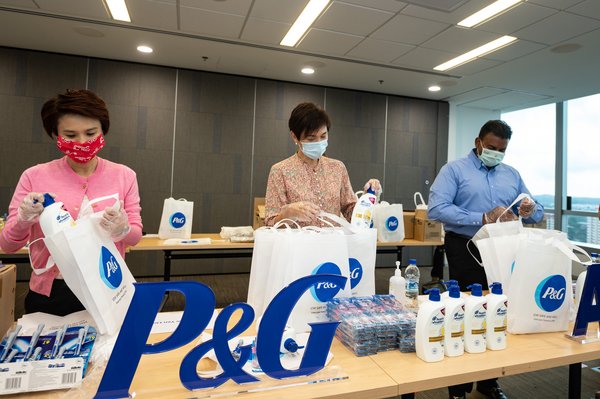 From L to R: (Ms. Low Yen Ling, Mayor of South West District, Ms. Josephine Teo, Minister for Manpower and Second Minister for Home Affairs, together with Mr. Magesvaran Suranjan, President of P&G AMA, packing the care packs which will be donated to migrant workers in Singapore)
