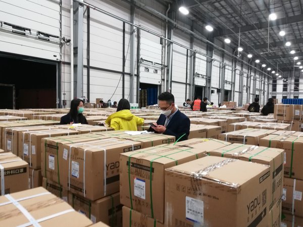 In a Tmall Supermarket warehouse in Zhejiang Province, China, Alibaba.com representatives inspect goods ordered by overseas buyers