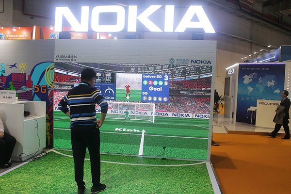 A visitor experiences an interactive football shooting game supported by 5G technology at Nokia's exhibition stand during the First China International Import Expo on Nov. 8, 2018.