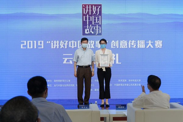 图为中国外文局局长杜占元（左）为优秀组织奖单位代表北京广播电视台外语广播台台长张晶宇颁奖。