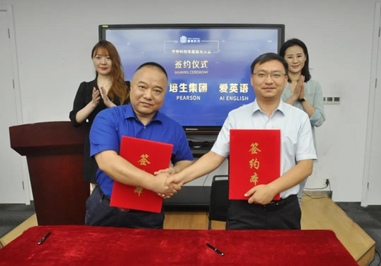 培生中国区销售总监费成龙与爱英语中国区总经理杨斌斌共同签署合作协议