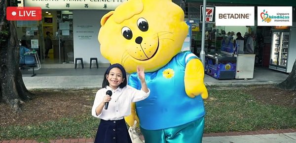 Budding reporter, Eva Alemany-Chia, and Singa, the mascot of Singapore Kindness Movement, distributed care packages to General Practitioners