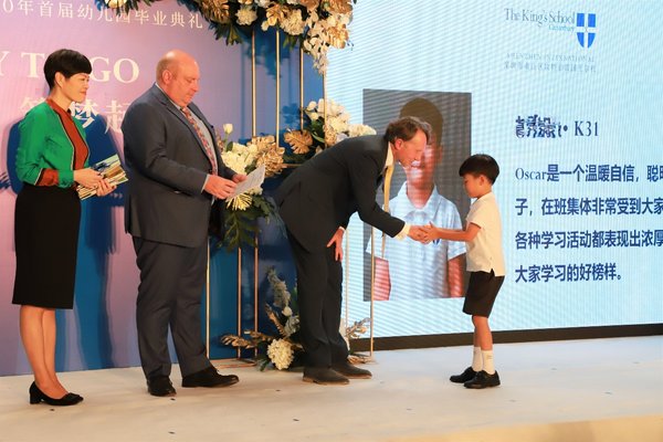 深圳南山国王学校首届幼儿园毕业典礼。每个孩子都落落大方地走上台，与Geoff校长握手，并礼貌地接过园长手中的毕业证书及礼物。