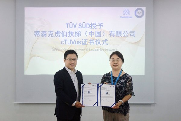 TUV南德建筑与基础设施部经理王鹏先生（左）为蒂森扶梯项目负责人高级工程师陈卫红女士（右）颁发cTUVus证书