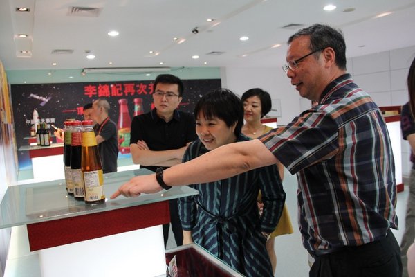 李锦记全球制造总监莫国栋（右）向新会生产基地来访嘉宾介绍产品